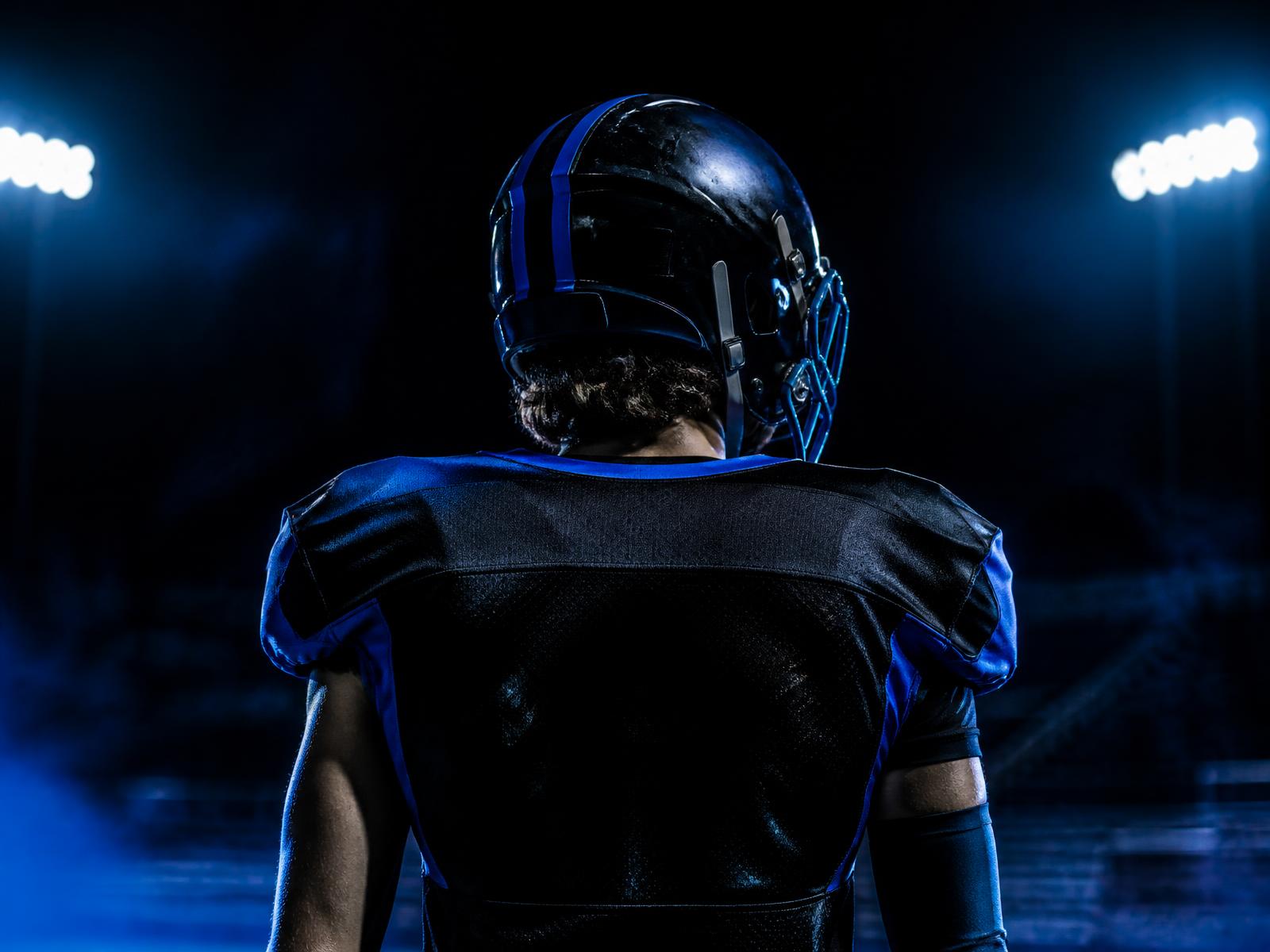 Dover High Football player under stadium lights